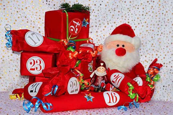 Un calendrier de l'Avent créatif fait de paquets cadeaux rouges et d'un Père Noël en peluche.