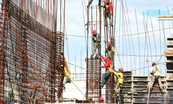 Ouvriers en hauteur sur une structure en ferraillage complexe, soulignant l'importance de la mobilité sur le chantier