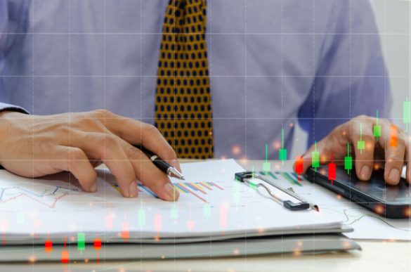 Gros plan d'un expert financier analysant des données boursières et des courbes de gestion d'actifs superposées à des documents papier