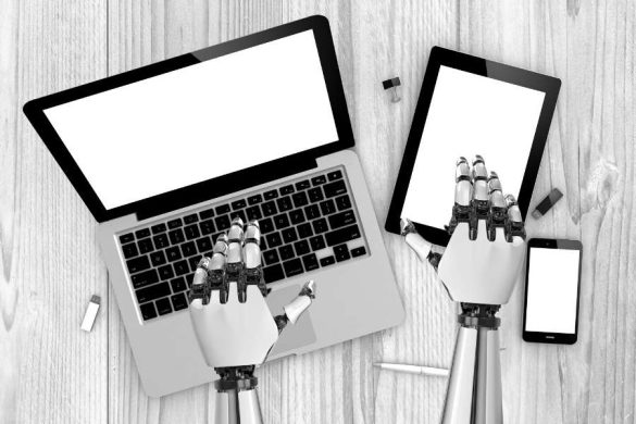 Des mains de robot en métal tapent sur le clavier d'un ordinateur portable et une tablette.
