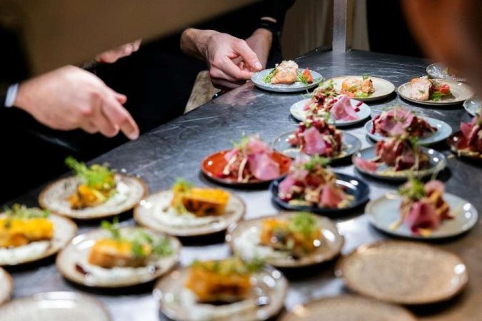 Des chefs préparent activement des assiettes raffinées au sein d'une cuisine professionnelle pour des destinations culinaires.